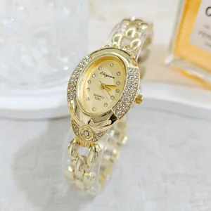 Close-up of a vintage luxury oval rhinestone quartz watch with a gold chain bracelet.