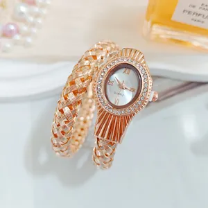 Détail de la montre quartz femme or rose, cadran ovale avec strass et bracelet tissé.