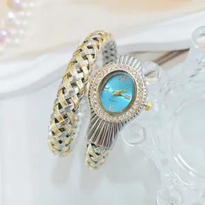 Vue détaillée de montre quartz pour femme avec cadran bleu, lunette en strass et bracelet tressé.