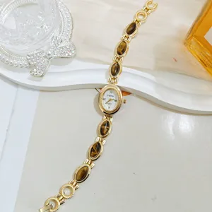 Vintage tiger eye gemstone quartz women watch, elegant gold bracelet wristwatch detail view.