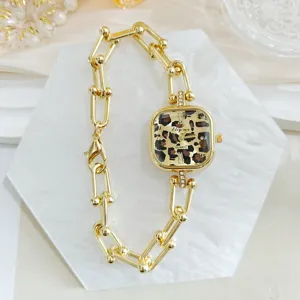 Detailansicht der goldenen quadratischen Uhr mit Leopardenmuster und auffallendem Gliederarmband.