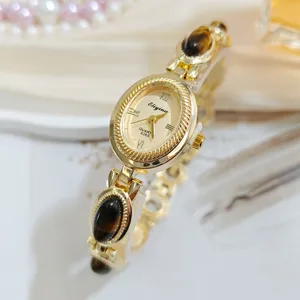 Vintage tiger eye gemstone bracelet watch detail, elegant retro oval quartz timepiece.