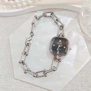 Nahaufnahme einer eleganten quadratischen Damenuhr mit Zirkonia und stilvollem Gliederarmband.