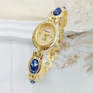 Vintage gold tone ladies quartz watch with blue stone inlaid bracelet, elegant dial design.