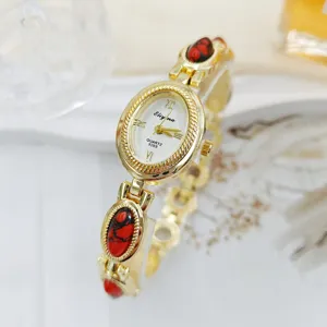 Vintage style oval quartz women watch with red stone bracelet detail, elegant gold accessory.
