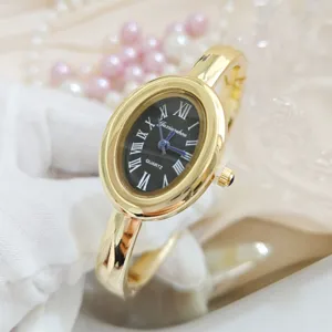 Gold oval bangle watch for women, vintage roman numerals black dial quartz wristwatch.