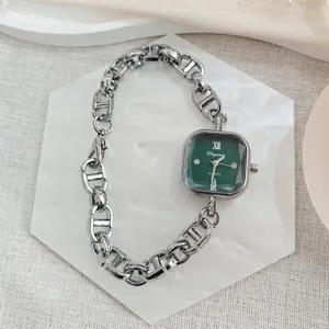 Elegante quadratische Damenarmbanduhr mit grünem Zifferblatt und klobigem Kettenarmband.