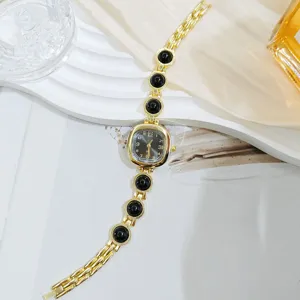 Elegante reloj de pulsera dorado para mujer con cuentas negras, movimiento de cuarzo.