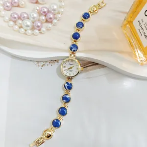 Elegante Quarzuhr mit blauen Perlen und Goldarmband für Damen im Detailansicht Design.