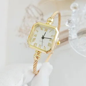 Primo piano di orologio bracciale quadrato dorato al quarzo, elegante quadrante bianco romano.