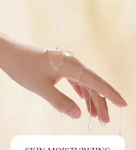 Vue détaillée de la texture d'huile hydratante qui coule doucement sur la peau de la main.