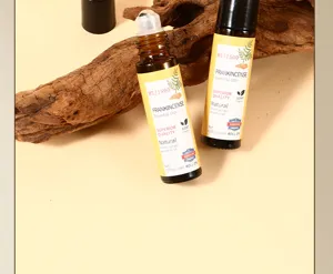 Détourage et détail de flacon d'huile essentielle à bille ambrée sur support en bois.