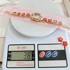 Goldfarbene Damen Armbanduhr mit quadratischen Strasssteinen und eleganter Gliederkette
