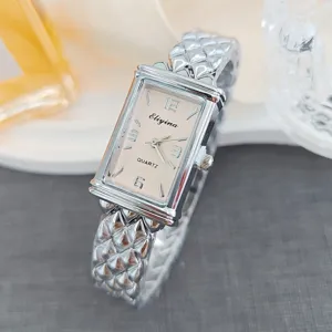 Detailansicht der Damen Quarzuhr mit rechteckigem Zifferblatt und gestepptem Metallarmband.