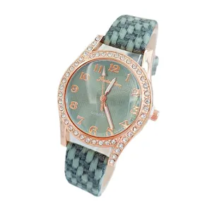 Elegante Damen Quarzuhr mit grünem geflochtenem Lederarmband und glitzerndem Roségold Strass Gehäuse.