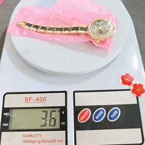 Vista dettagliata dell'elegante orologio da polso con strass da donna e cinturino oro-nero.