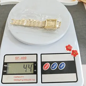 Close-up detail shot of the gold square quartz watch on a digital scale, weighing 44g.
