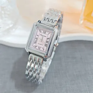 Detailed shot of a silver rectangular quartz watch with a pink dial and Roman numerals.