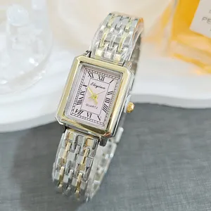 Close-up detail of vintage rectangular women quartz watch with pink dial and Roman numerals.
