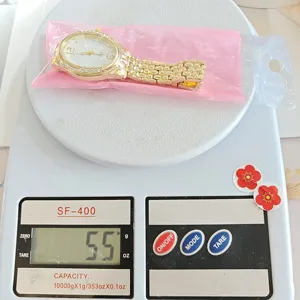 Detailaufnahme einer goldenen Quarzuhr mit Zirkonblatt und Metallarmband verpackt.