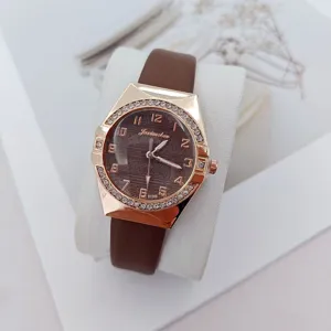 Detailed view of women quartz wristwatch featuring brown leather strap and rhinestone bezel.