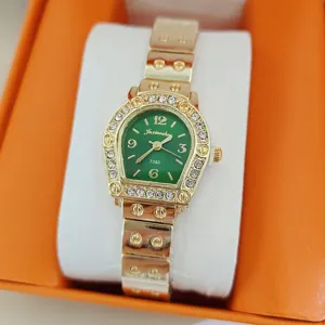 Vue détaillée de la montre quartz femme avec cadran vert et lunette en strass brillants.
