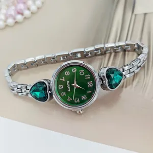 Detailed view of women quartz watch with green dial and heart crystal silver bracelet.