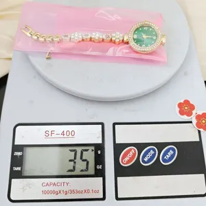 Green dial rhinestone flower link quartz watch detail showing weight on digital scale.