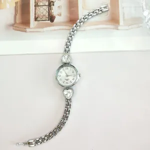 Detailed view of women silver quartz watch with heart crystal design on sleek strap.