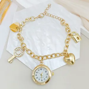 Detailopname van gouden bedelarmband horloge met hart, hangslot en schitterende strass sleutels.