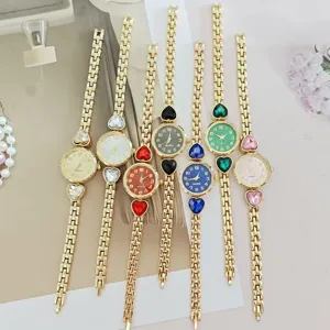 Detail view of women's quartz watches featuring gold chain straps and colorful heart gemstones.