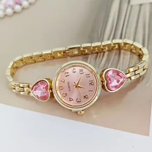 Close up view of women pink dial quartz watch featuring elegant heart diamond and gold chain.