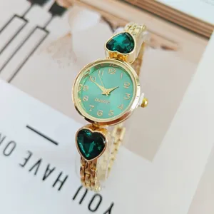Detail shot of luxury gold quartz watch with green dial and heart crystal bracelet links.