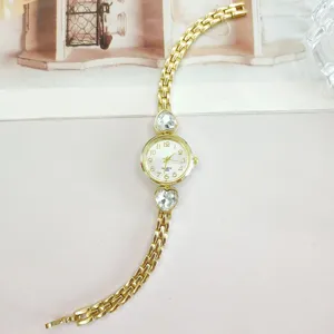 Women's gold-tone quartz watch featuring elegant heart rhinestone accents and linked metal band.