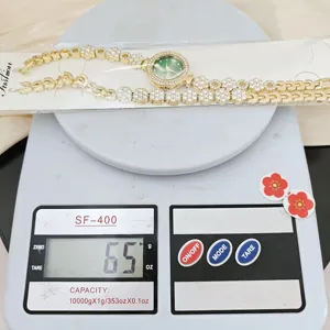 Luxury diamond-encrusted green dial women's quartz watch with elegant floral chain strap detail.