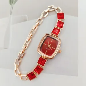 Gouden dames quartz horloge met vierkante rode wijzerplaat en rode kristallen armband.