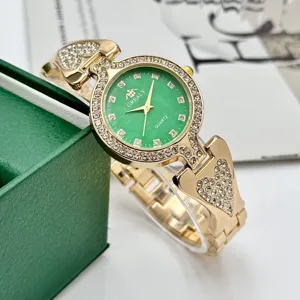 Reloj de cuarzo para mujer con esfera verde, pulsera de estrás dorada y detalles brillantes.