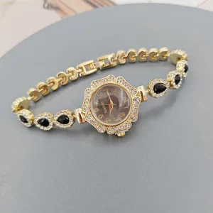 Primer plano del detalle de reloj de cuarzo dorado para mujer, diseño elegante de estrás y piedra.