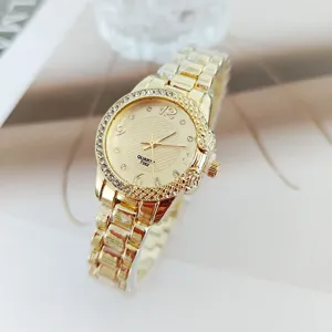 Montre femme quartz strass or vue de detail, bracelet metal elegant et cadran brillant.