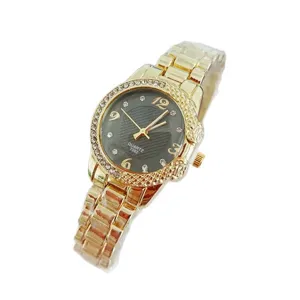 Vue détaillée de la montre quartz dorée pour femme avec lunette en strass étincelante et cadran.