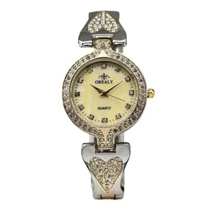 Detalle del reloj de cuarzo para mujer con pedrería brillante y brazalete de corazón.