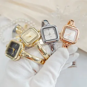Gedetailleerde close-up van vierkant quartz horloge met stijlvolle metalen armband in diverse tinten.