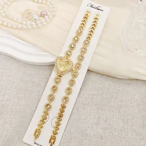 Detailansicht des goldenen Damen Herz Strass Uhrensets mit funkelnden Kristallen und Karte.