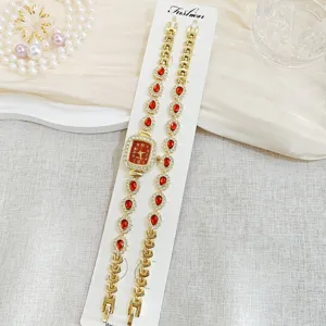 Elegantes Damen Quarzarmbanduhr und passendes Armband Set mit roten Strasssteinen geschmückt.