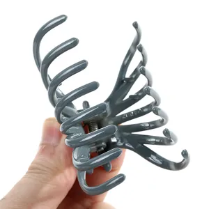 Close-up detail of grey plastic hair claw clip, sturdy design and strong spring for thick hair.