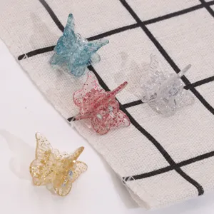Detailed close-up of cute mini butterfly hair claw clips with colorful glitter resin.