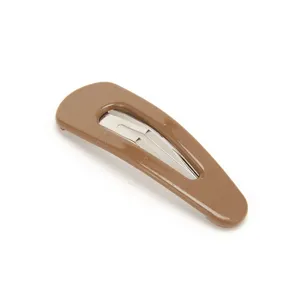 Brown metal snap hair clip close-up showing glossy painted finish and minimalist daily style.