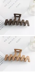 Close up of large plastic hair claw clip, vintage matte brown shark hair styling accessory detail.