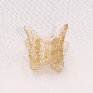 Close-up of a cute glitter butterfly hair claw clip in jelly gold color, detail feature.