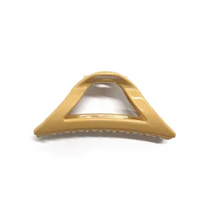 Primo piano del morsetto per capelli triangolare in plastica kaki lucida con superficie liscia.
